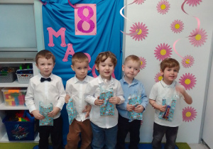 Chłopcy pozują do zdjęcia. Z tyłu dekoracja.