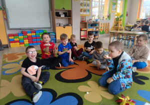 Przedszkolaki dmuchają na piłeczki steropianowe.