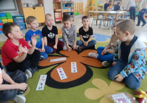 Dzieci usprawniają wargi i język, wykonując ćwiczenia, które umieszczone są pod obrazkami zwierząt.