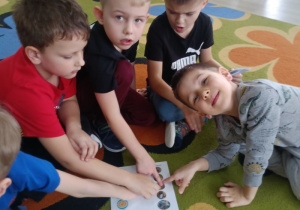 Chłopcy wskazują palcami na obrazek słonia.