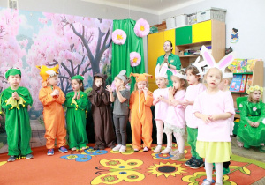 Na scenie stoją dzieci w przebraniach zwierzątek.