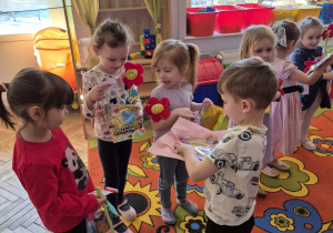 Wojtuś stoi przed Jagodą i Patrycją trzymając w ręku tackę z kolejnym upominkiem ufundowanym z Rady Rodziców.