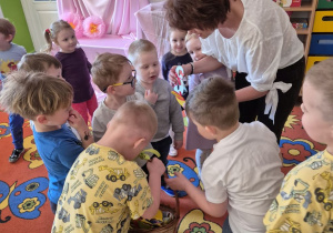 Chłopcy z grupy składają życzenia i wręczają słodki upominek cioci Alicji.