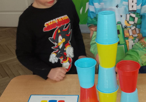 Mikołaj i Staś zbudowali wieżę według określonego kodu i sprawdzają poprawność wykonanego zadania na karcie wzoru.