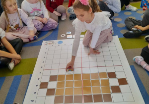 Marysia na podstawie podanych koordynatów układa na macie symbol przedstawiający tęczę.