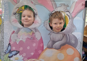 Weronika i Bruno pozują do zdjęcia w wielkanocnej fotobudce.