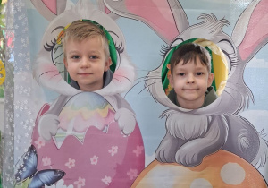 Wiktor i Mateusz pozują do zdjęcia w wielkanocnej fotobudce.