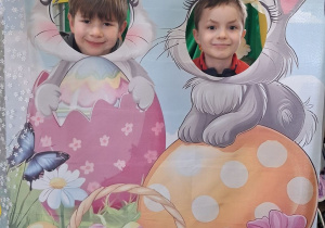 Staś i Bartek pozują do zdjęcia w wielkanocnej fotobudce.