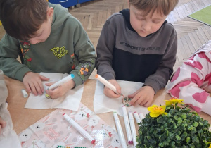 Hubert i Mateusz podczas kolorowania pisanek.