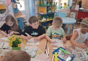 Grupka dzieci podczas pracy dekorowania pisanek.