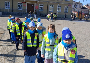 Przedszkolaki ustawione parami na Placu Piłsudskiego. W tle budynek Urzędu Miasta Kutno.