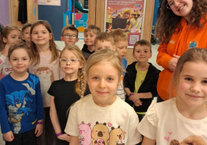 Dzieci stoją razem z Panią animator przed wejściem na salę zabaw.