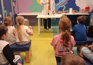 Dzieci obserwują jak skurczyły się balony zanurzone w ciekłym azocie.