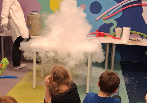 Dzieci oglądają doświadczenie z wrzątkiem i ciekłym azotem.