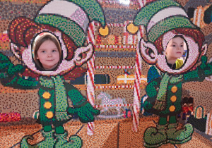 Weronika i Bartek pozują do zdjęcia w fotobudce z klocków.