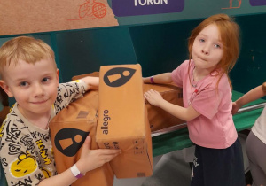 Emma i Fabian wyjmują paczki z dostawczej ciężarówki.