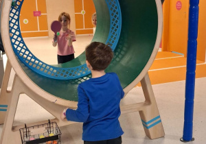 Bartek i Emma grają w tenisa stołowego na okrągłym stole w formie tunelu.