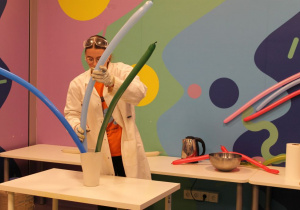 Pani animator wkłada balony do pojemnika z ciekłym azotem.