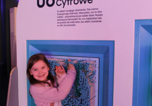 Weronika z radością bawi się przy ściance "Ślady cyfrowe".
