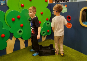 Dwóch chłopców bawi się w "Jabłkowym sadzie".