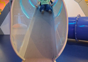 Staś zjeżdża na zjeżdżalni.