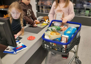 Julek, Zuzia i Weronika bawią się w strefie Mądrych Zakupów.