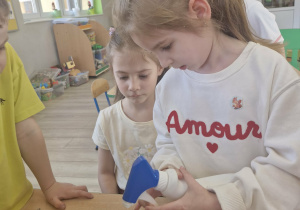 Oliwia podlewa rzeżuchę.