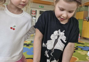 Liliana i Maja obserwują doniczki z kiełkującym owsem.