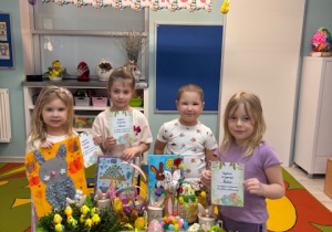 Grupa biedronek przy stoliczku z ozdobami świątecznymi pozuje do zdjęcia.