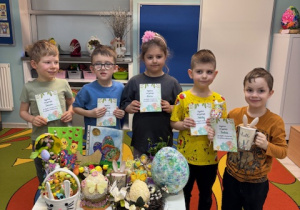 Grupa słoneczek przy stoliczku z ozdobami świątecznymi pozuje do zdjęcia.