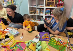 Nikoś pozuje do zdjęcia z ozdobioną kurką w obiektywie swojej babci.