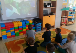 Dzieci oglądają prezentację o wesołym miasteczku.