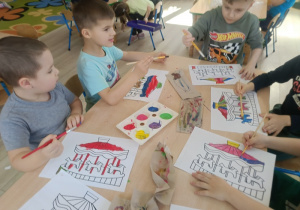 Dzieci malują farbami kontur karuzeli.