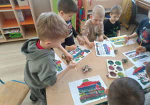 Dzieci malują farbami.