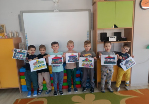 Biedronki prezentują swoje prace przy tablicy multimedialnej.