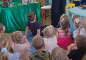 Pani prezentuje dzieciom obrazek w przestrzennej formie pt. "Kolorowy potwór". w książce