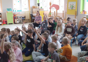 Dzieci zgłaszają się do odpowiedzi na pytania zadawane przesz panią leśnik.