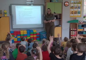 Dzieci oglądaja prezentację i zgłaszają się do odpowiedzi.