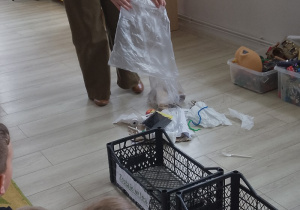 Pani wysypuje różne przedmioty ze skrzynki.