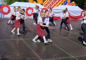 Dzieci tańczą po kole w parach.