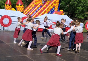 Dzieci tworzą dwa koła: w środku tańczą chłopcy na zewnątrz dziewczynki.