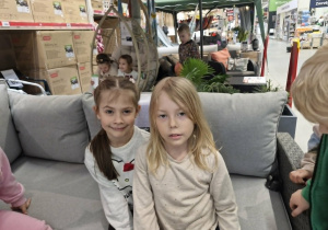 Oliwia i Nadia pozują do zdjęcia siedząc na kanapie.