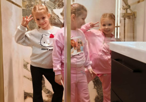 Oliwia, Klara i Ala pozują do zdjęcia w nowoczesnej kabinie prysznicowej.
