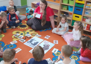 6. Dzieci siedzą z panią na dywanie, na środku leżą odsłonięte karty, dzieci opowiadają z czym dany obrazek się kojarzy.