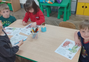 7. Grupka dzieci koloruje obrazki.