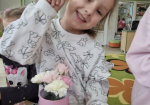 Zuzanna uśmiecha się w trakcie robienia bukietu dla mamy.