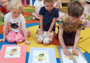 Kornelia, Nikodem i Leon kończą układanie pociętych obrazków z wizerunkiem pszczoły.