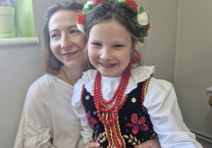 Maja pozuje do zdjęcia siedząc na kolanach swojej mamy.