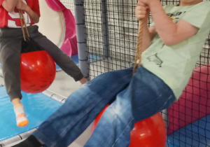 Hubert i Staś huśtają się na piłkach.