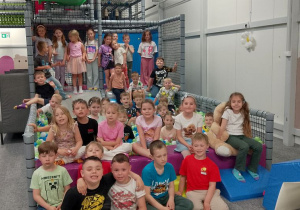 Dzieci w grypy "Słoneczka" i "Biedronki" pozują do wspólnego zdjęcia w sali zabaw.